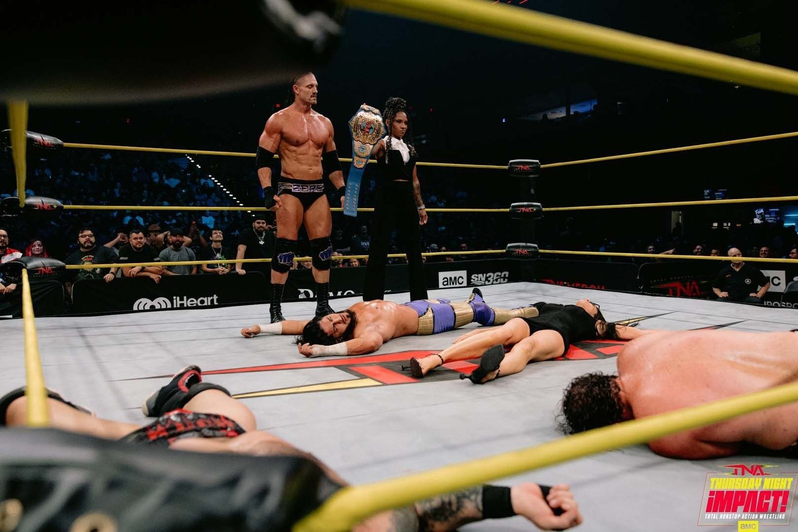 Special Agent 0 de pie con el cinturón junto a Tasha Steelz y luchadores tendidos en el ring de TNA iMPACT del 1 de octubre de 2026